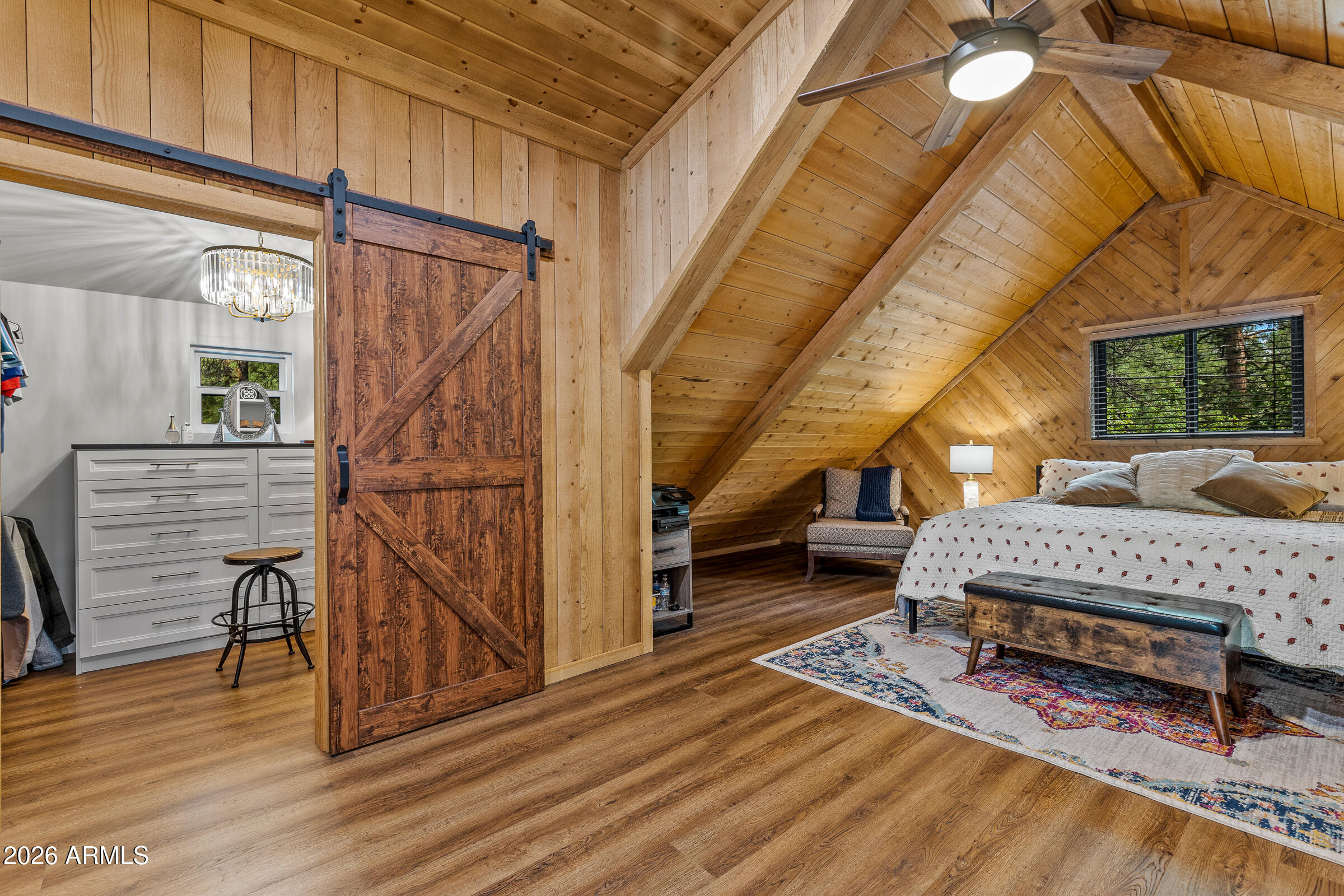 755 East Meadow View Road Munds Park, AZ 86017 - Photo 23 of 35 a bedroom with a bed a table and wooden floor