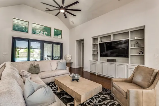 a living room with furniture a flat screen tv and a window