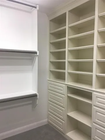 a view of walk in closet with empty racks