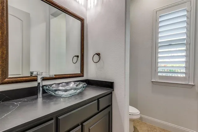 a bathroom with a sink a toilet and a window