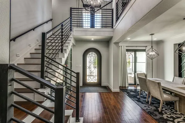 a view of a hallway with wooden floor windows a kitchen and stairs