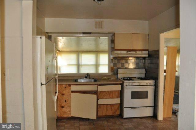 6005 Johnnycake Road Catonsville, MD 21228 - Photo 6 of 10 a kitchen with a stove and a refrigerator