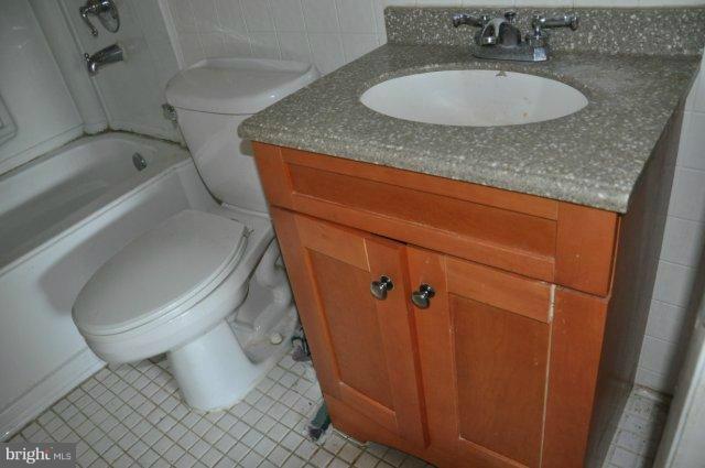 6005 Johnnycake Road Catonsville, MD 21228 - Photo 8 of 10 a bathroom with a granite countertop sink toilet and shower