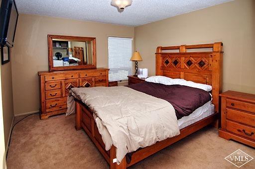 907 Red Sandstone Road, Unit 9C Vail, CO 81657 - Photo 3 of 7 a bedroom with a bed and a lamp on dresser