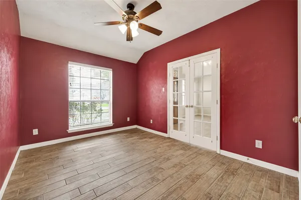 an empty room with windows and fan