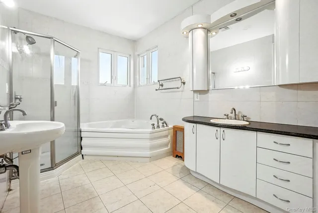 a spacious bathroom with a double vanity sink mirror and bathtub