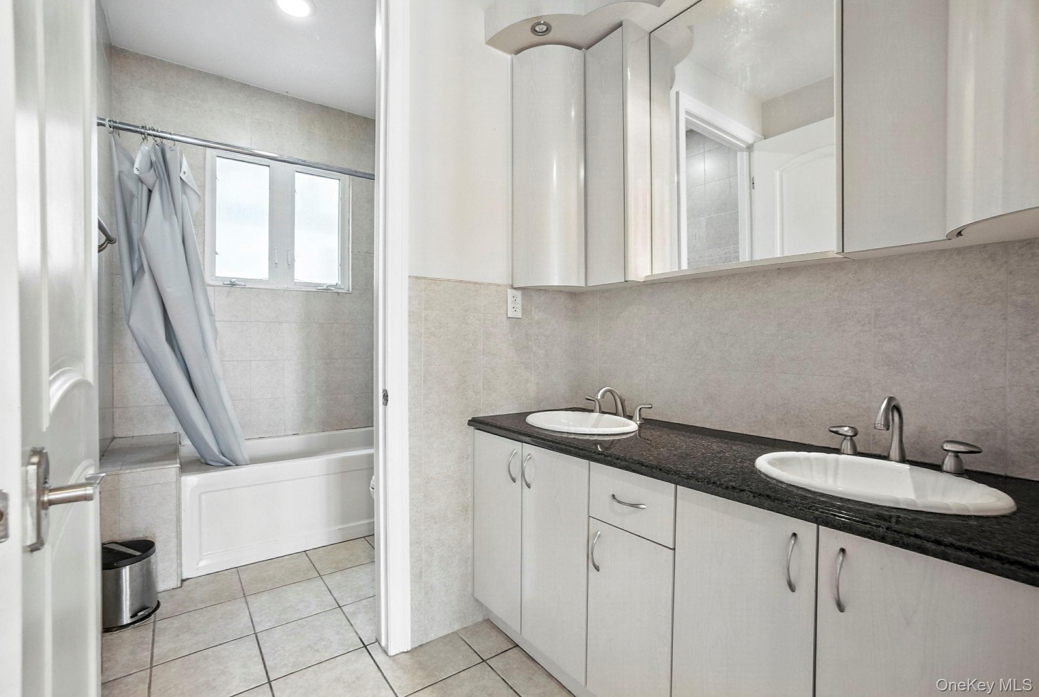 77-16 Kew Forest Lane Queens, NY 11375 - Photo 16 of 28 a bathroom with a sink and a mirror