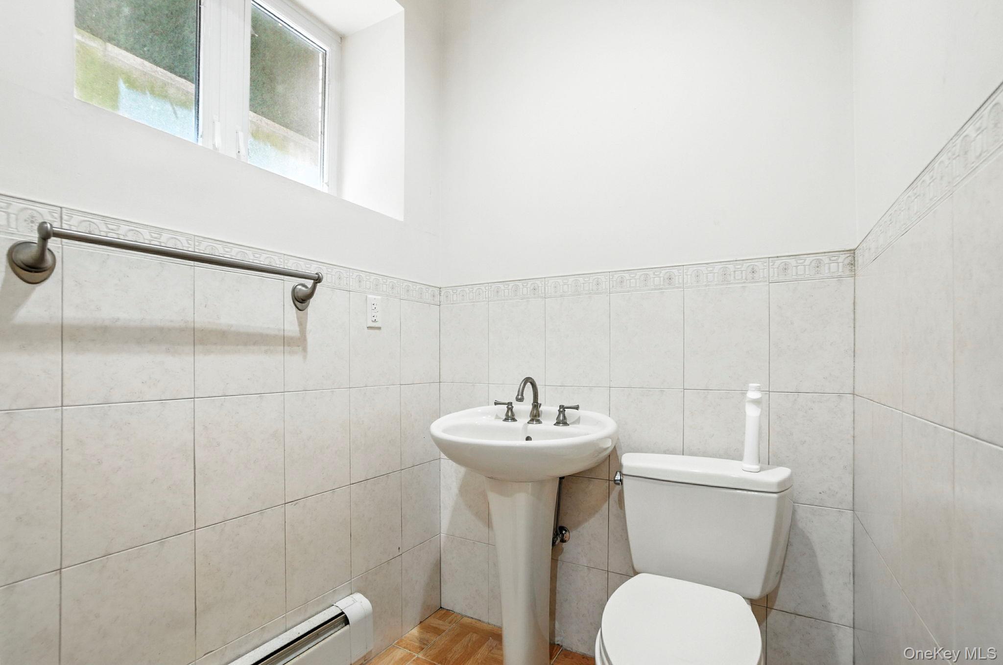 77-16 Kew Forest Lane Queens, NY 11375 - Photo 19 of 28 a bathroom with a sink toilet and a mirror