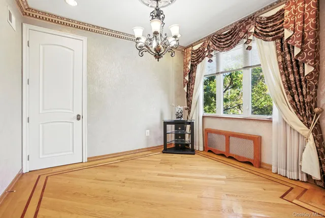 a view of empty room with a fireplace and chandelier