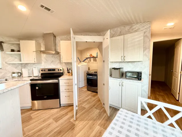 a kitchen with stainless steel appliances granite countertop a stove refrigerator and a sink