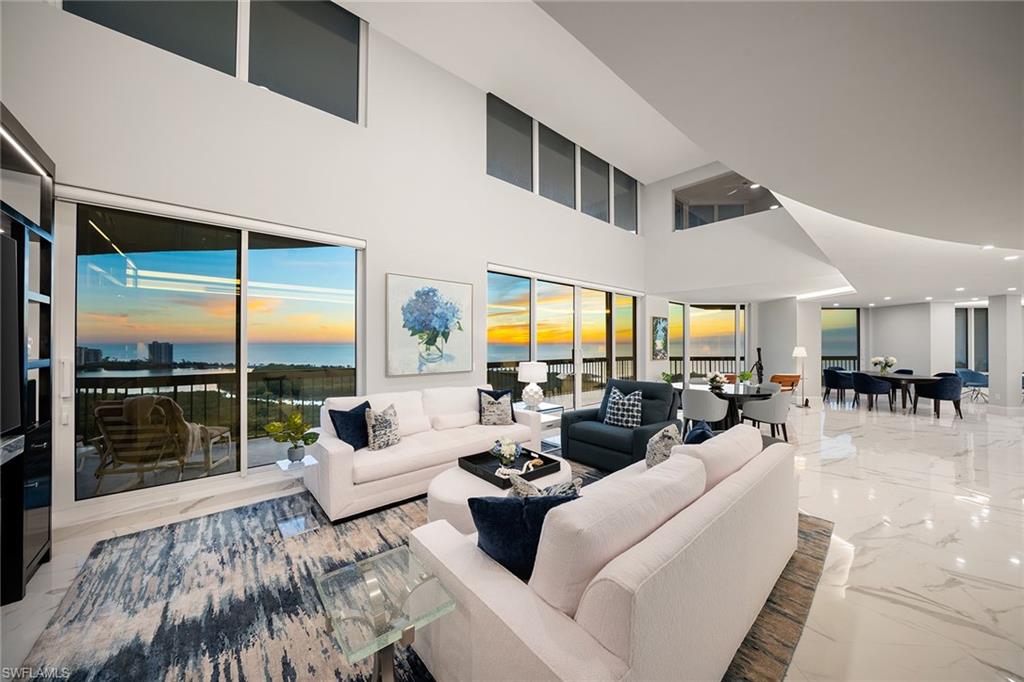 6001 Pelican Bay Boulevard, Unit PHA Naples, FL 34108 - Photo 1 of 50 a living room with furniture and a large window