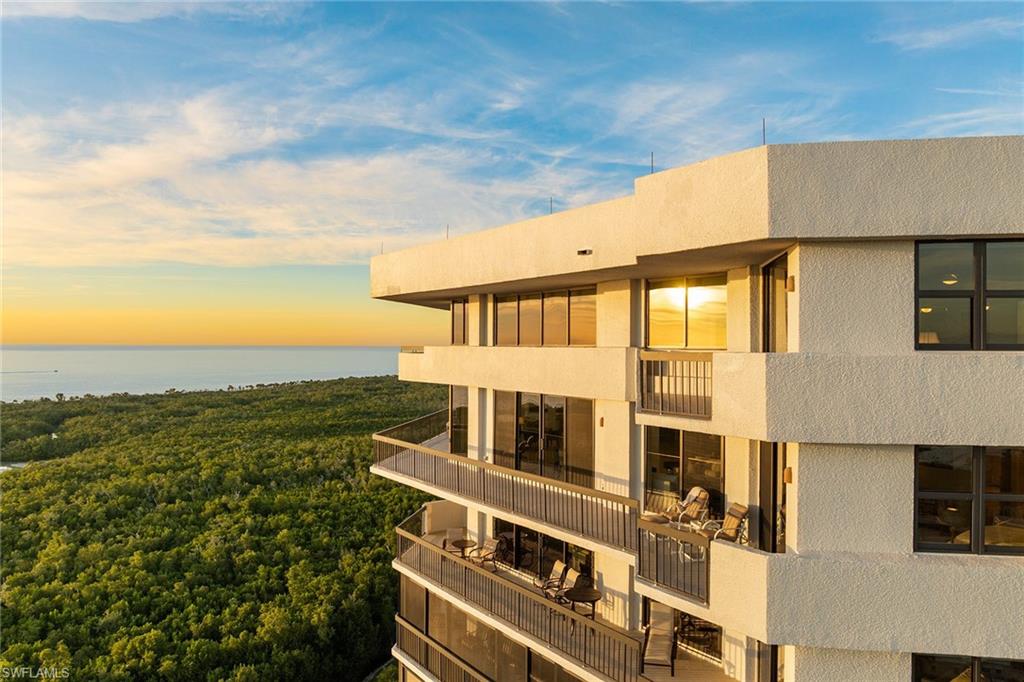 6001 Pelican Bay Boulevard, Unit PHA Naples, FL 34108 - Photo 13 of 50 a view of a big room with wooden floor and fence