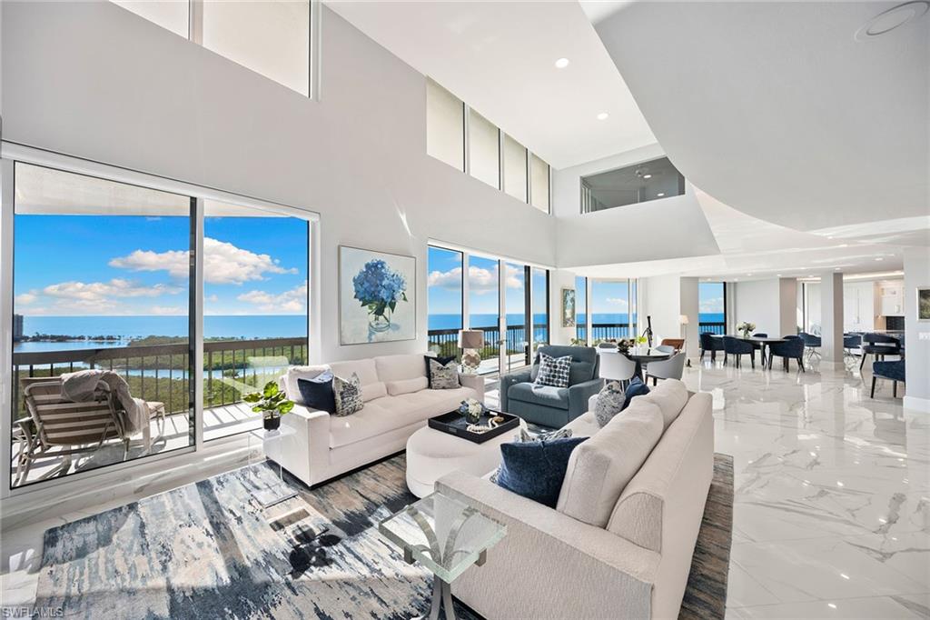 6001 Pelican Bay Boulevard, Unit PHA Naples, FL 34108 - Photo 16 of 50 a living room with furniture and a large window