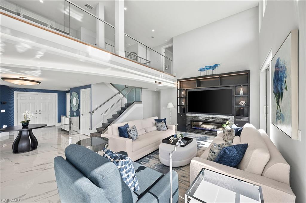 6001 Pelican Bay Boulevard, Unit PHA Naples, FL 34108 - Photo 20 of 50 a living room with furniture and a flat screen tv