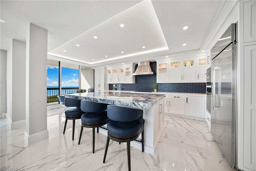6001 Pelican Bay Boulevard, Unit PHA Naples, FL 34108 - Photo 25 of 50 a kitchen with stainless steel appliances kitchen island granite countertop a sink and cabinets