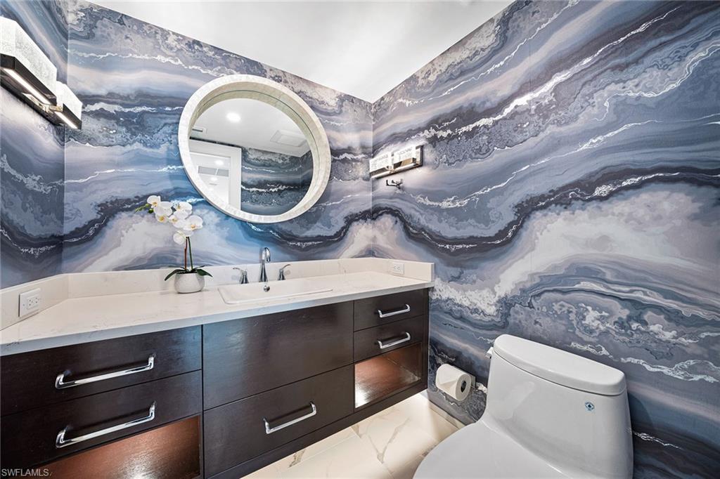 6001 Pelican Bay Boulevard, Unit PHA Naples, FL 34108 - Photo 31 of 50 a bathroom with a sink and a mirror