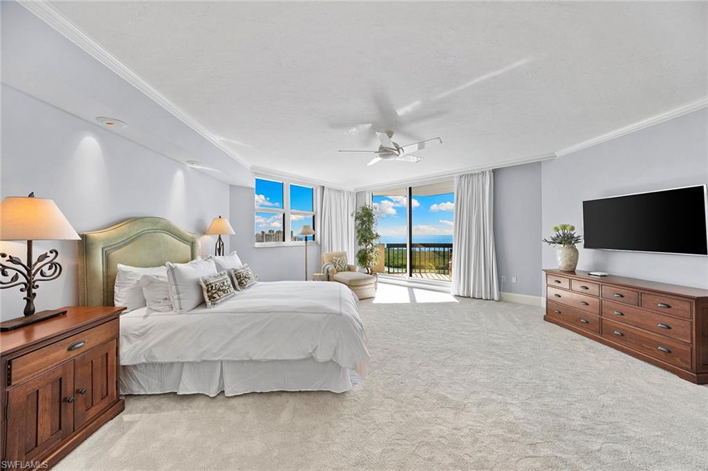 6001 Pelican Bay Boulevard, Unit PHA Naples, FL 34108 - Photo 34 of 50 a spacious bedroom with a bed and a flat screen television