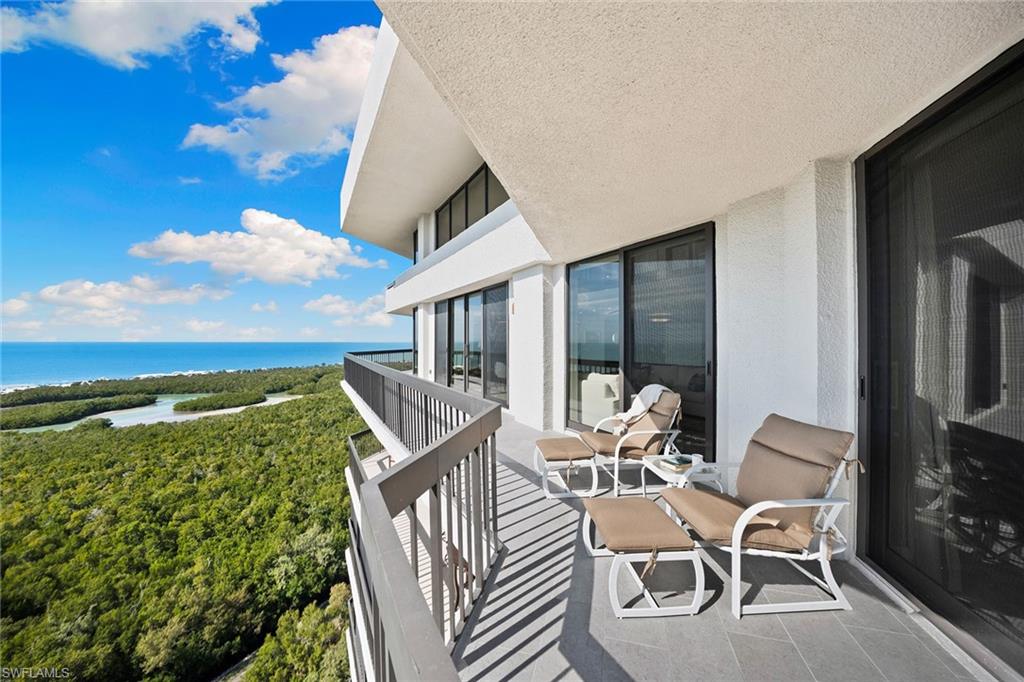 6001 Pelican Bay Boulevard, Unit PHA Naples, FL 34108 - Photo 35 of 50 a balcony with table and chairs