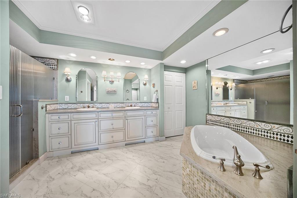 6001 Pelican Bay Boulevard, Unit PHA Naples, FL 34108 - Photo 36 of 50 a spacious bathroom with a granite countertop sink mirror and bathtub