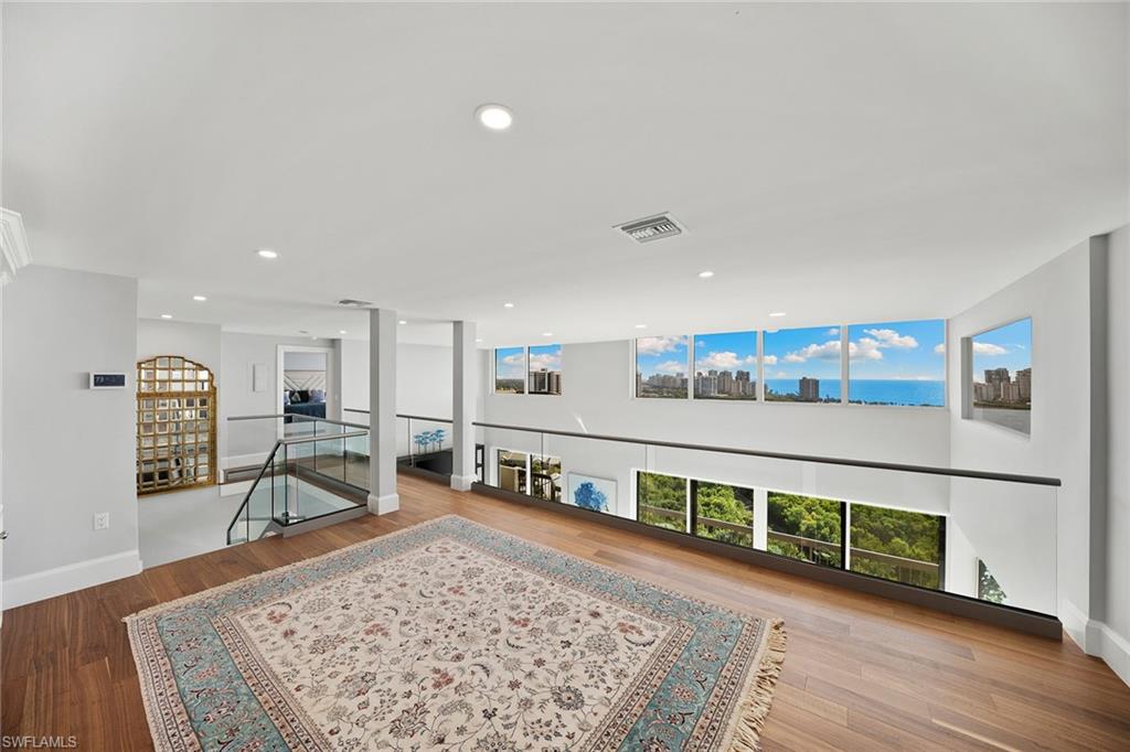 6001 Pelican Bay Boulevard, Unit PHA Naples, FL 34108 - Photo 37 of 50 a living room with a couch and a wooden floor