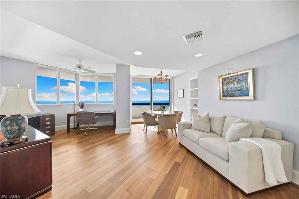 6001 Pelican Bay Boulevard, Unit PHA Naples, FL 34108 - Photo 39 of 50 a living room with furniture and a large window