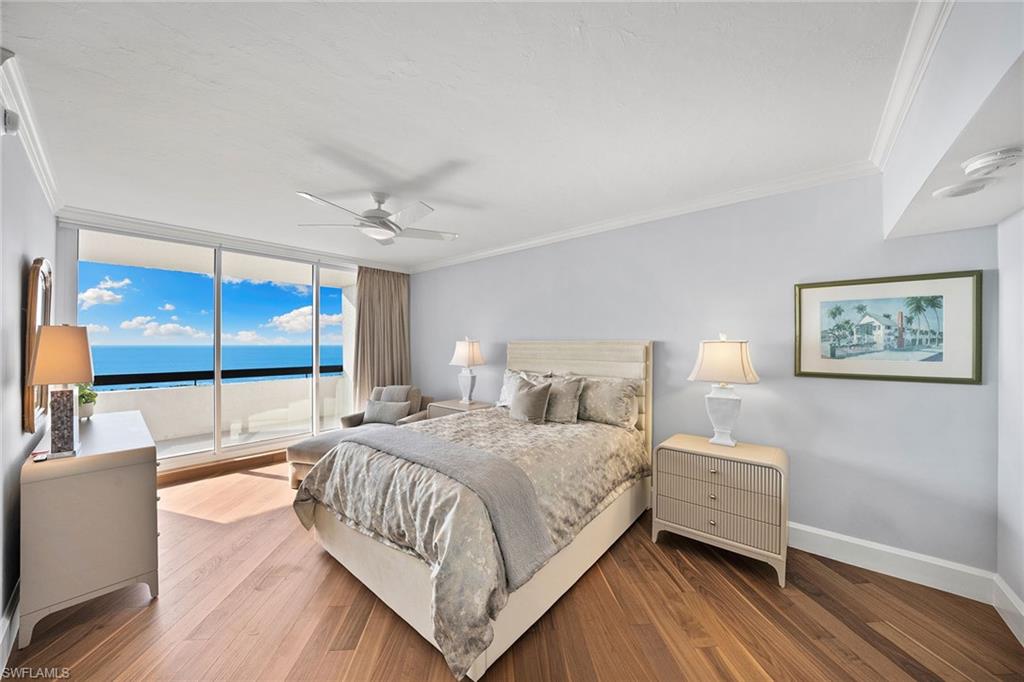 6001 Pelican Bay Boulevard, Unit PHA Naples, FL 34108 - Photo 43 of 50 a bedroom with a large bed a chandelier and windows