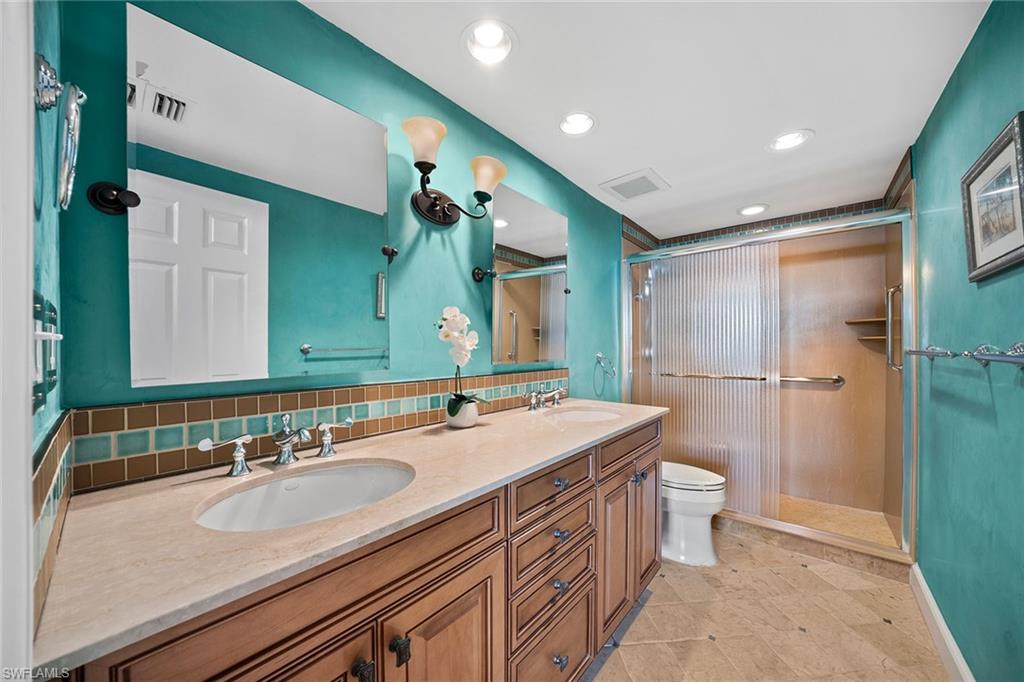 6001 Pelican Bay Boulevard, Unit PHA Naples, FL 34108 - Photo 44 of 50 a bathroom with a sink double vanity and a mirror