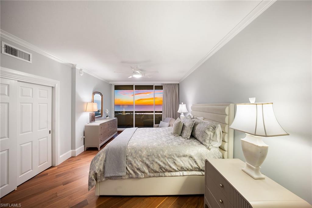 6001 Pelican Bay Boulevard, Unit PHA Naples, FL 34108 - Photo 7 of 50 a bedroom with a bed and wooden floor