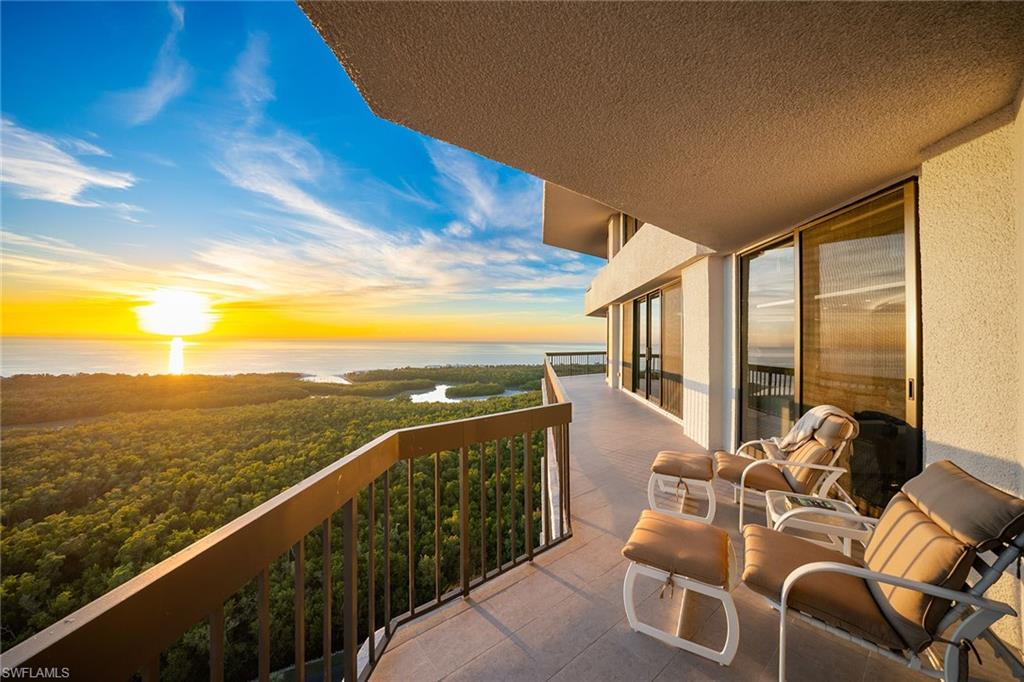 6001 Pelican Bay Boulevard, Unit PHA Naples, FL 34108 - Photo 8 of 50 a view of a balcony with chairs