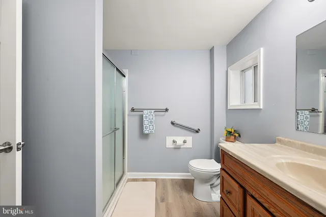 a bathroom with a granite countertop toilet a sink and a mirror