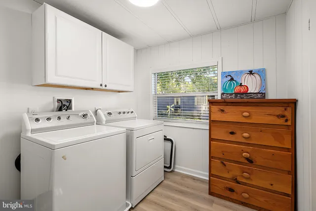 a view of cabinets a washer and dryer with white cabinets