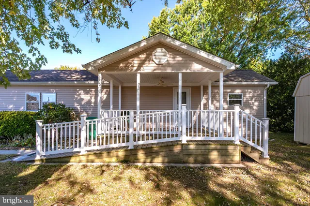 a view of a house with a small yard plants and large trees
