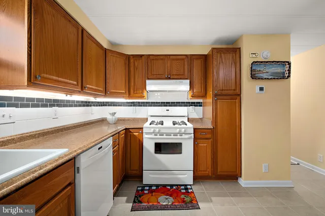a kitchen with a white stove top oven and sink