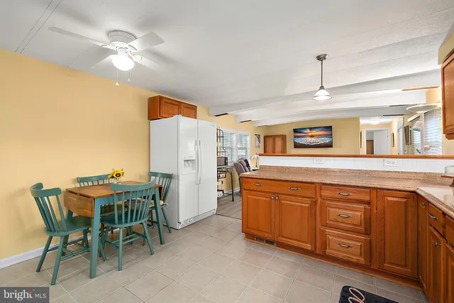 a dining hall with stainless steel appliances granite countertop a dining table and chairs with wooden floor