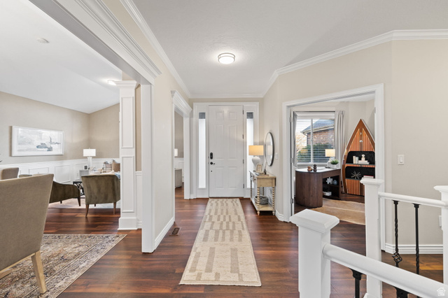 6208 West Bull River Road Highland, UT 84003 - Photo 4 of 90 Entryway featuring dark wood-finish flooring, white door with sidelight, crown molding, and wainscoting