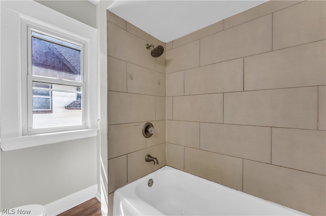 3506 Riverside Avenue Cleveland, OH 44109 - Photo 23 of 31 White alcove bathtub with tiled shower surround, bronze showerhead, and coordinating bath faucet