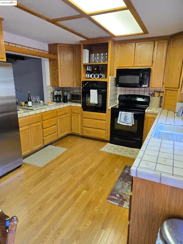 a kitchen with a sink cabinets and wooden floor