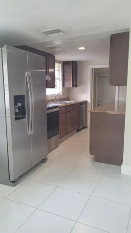 a kitchen with stainless steel appliances granite countertop a refrigerator and a stove