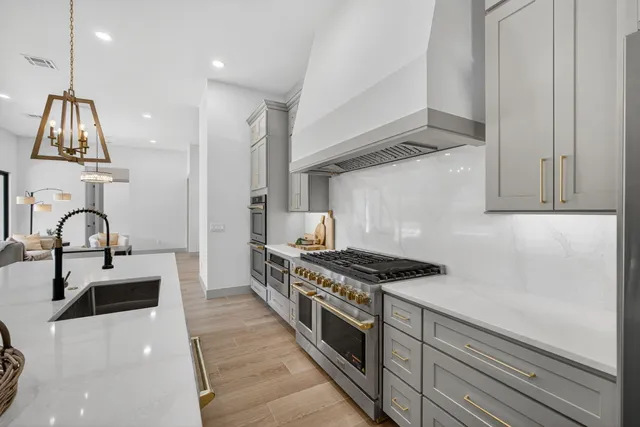 a kitchen with stainless steel appliances granite countertop a stove and a sink