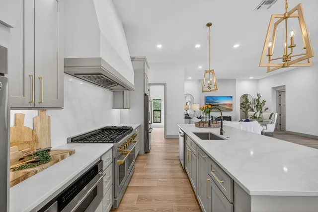 a kitchen with stainless steel appliances a sink stove and cabinets