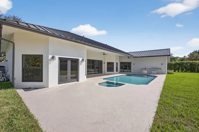 a front view of a house with a yard and potted plants