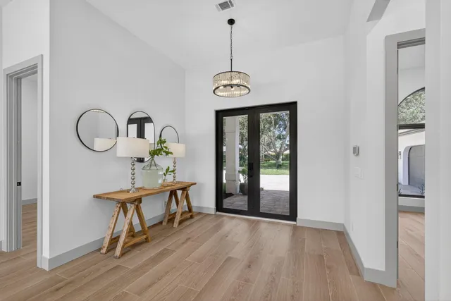 a view of a room with wooden floor mirror and a window