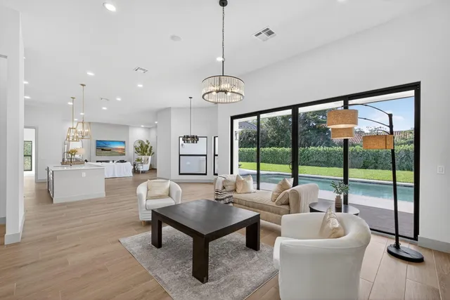 a living room with patio furniture and a floor to ceiling window