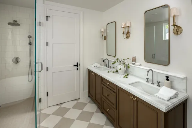 a bathroom with a double vanity sink mirror and shower