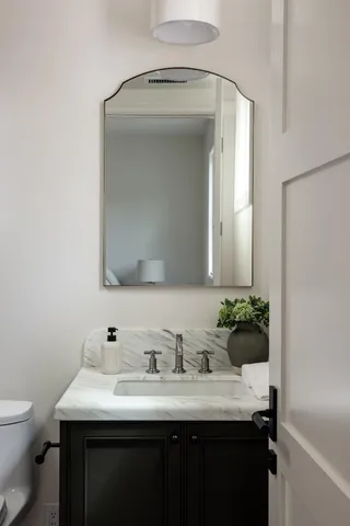 a bathroom with a granite countertop sink and a mirror