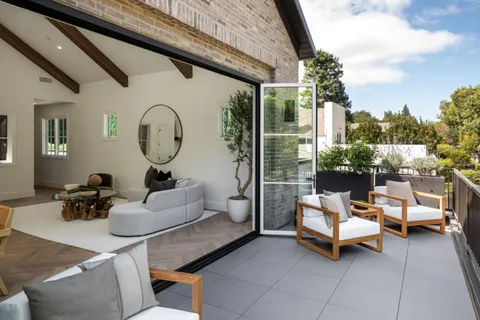 a living room with patio furniture and a potted plant