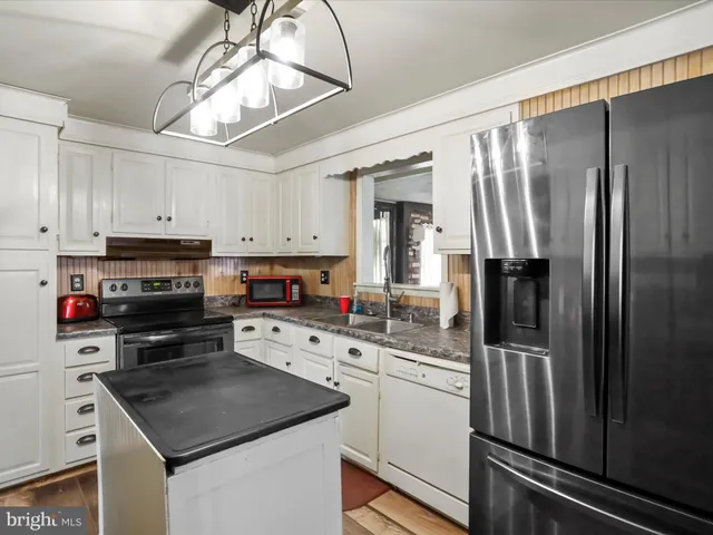 a kitchen with a refrigerator a stove a microwave and cabinets