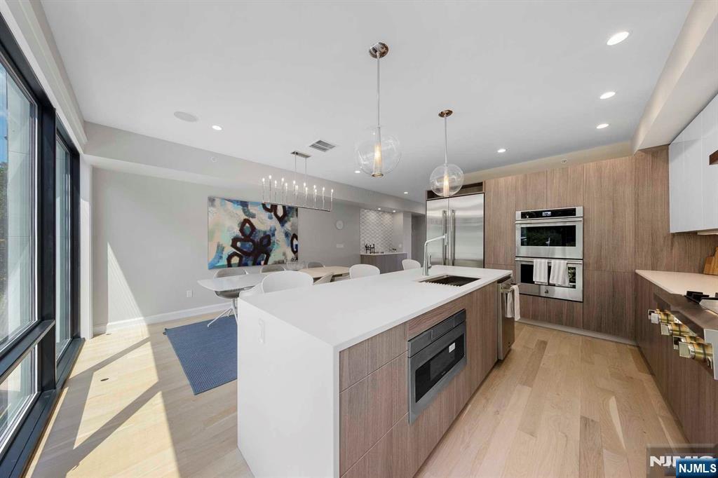 8822 Churchill Road North Bergen, NJ 07047 - Photo 41 of 50 a large kitchen with kitchen island a stove a sink a refrigerator and a refrigerator with wooden floor
