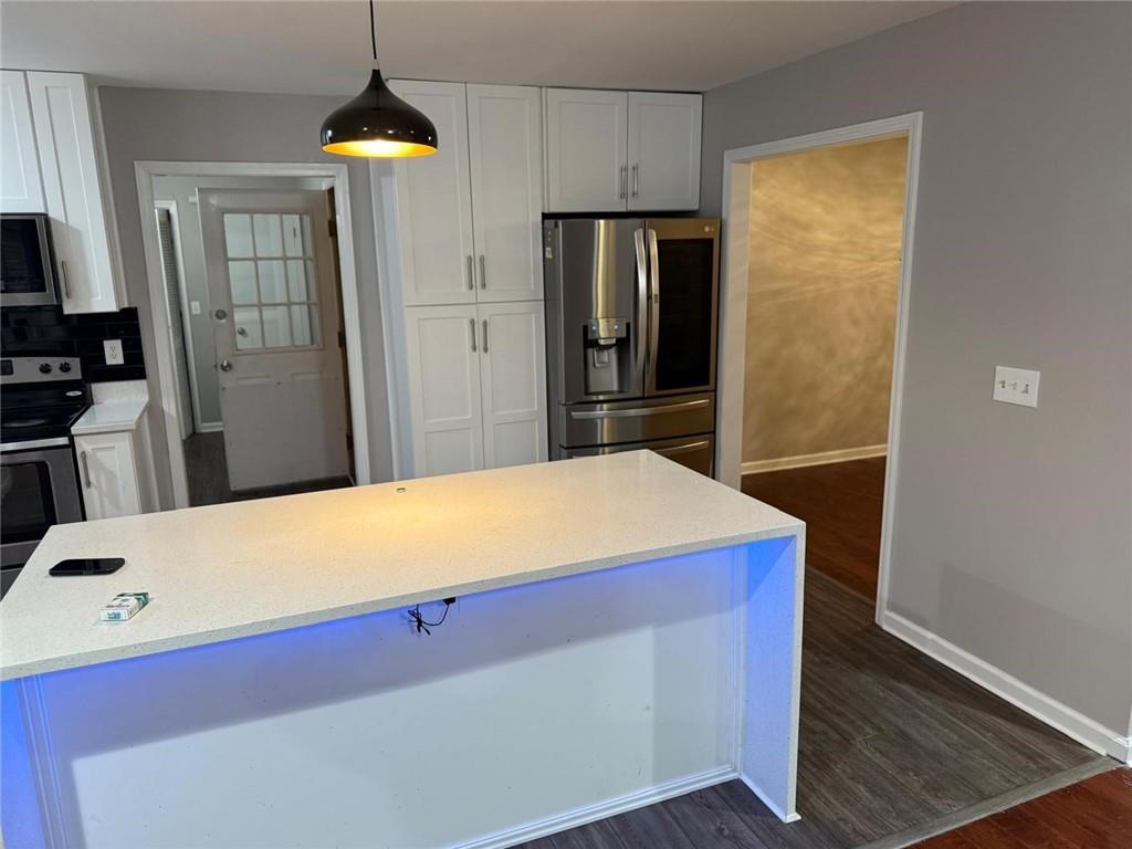 1682 Greyleaf Lane Southeast Dacula, GA 30019 - Photo 22 of 23 a room with stainless steel appliances a refrigerator and microwave