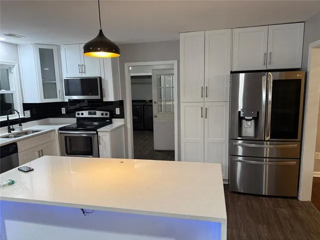 a kitchen with a sink cabinets and wooden floor